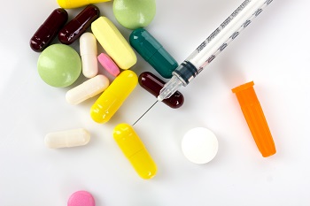 insulin syringe and colorful medicaments on white background