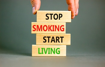 Stop smoking start living symbol. Concept words Stop smoking start living on cubes. Beautiful grey background.
